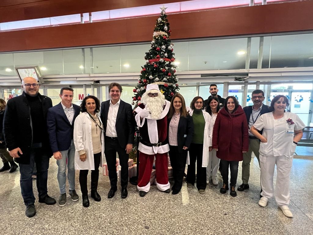 Papá Noel, el alcalde, miembros de la Corporación y del Hospital en el reparto del regalos a niñas y niños