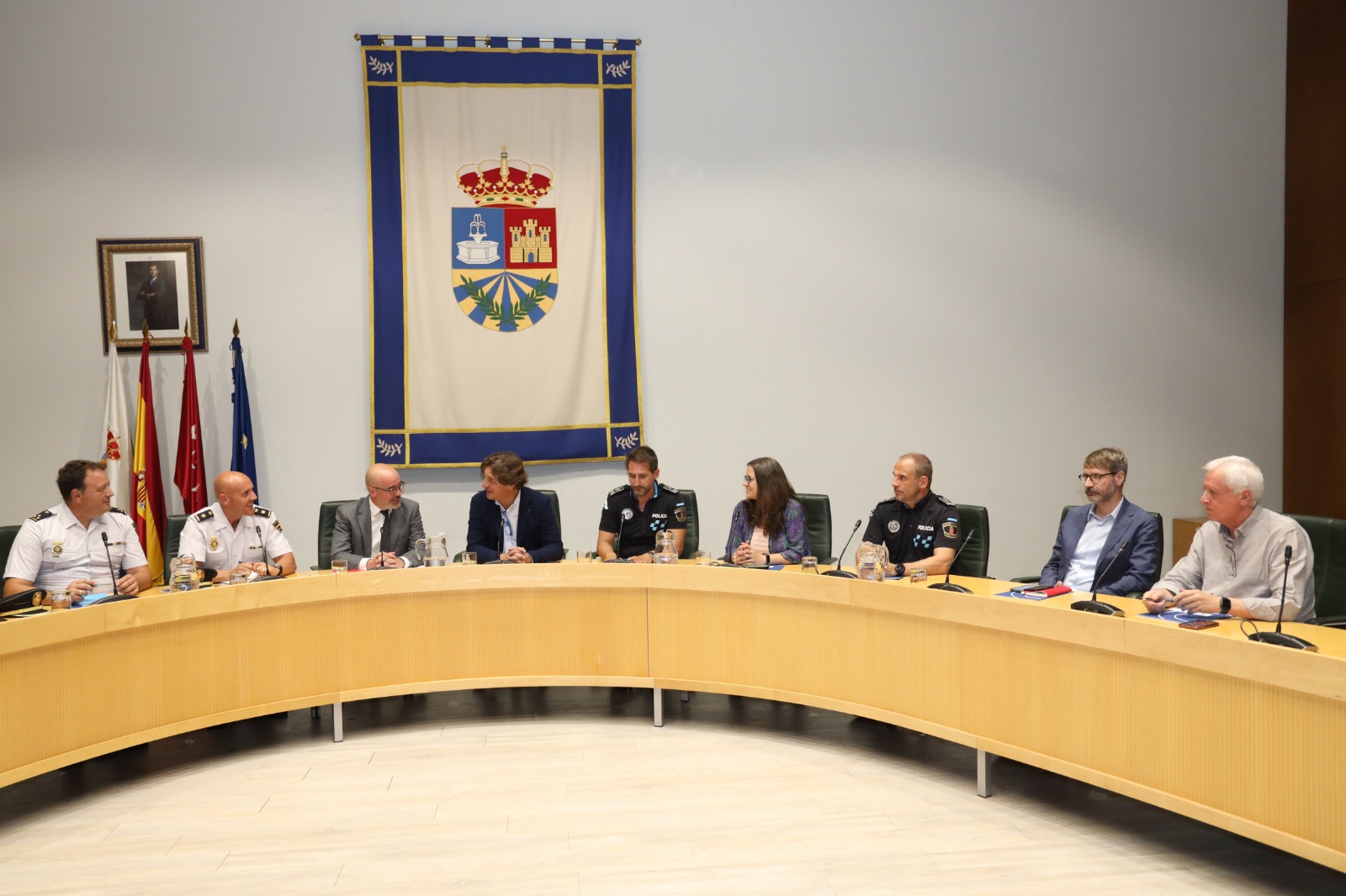 El alcalde, el delgado del Gobierno y varios policías sentados en la mesa del salón de pleno