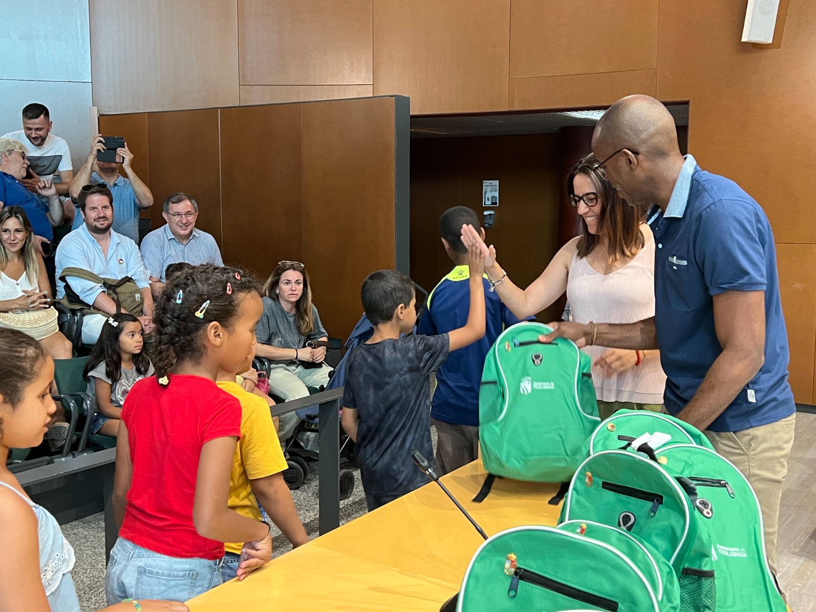 Niños y niñas saharauis recogiendo como regalo una mochila verde