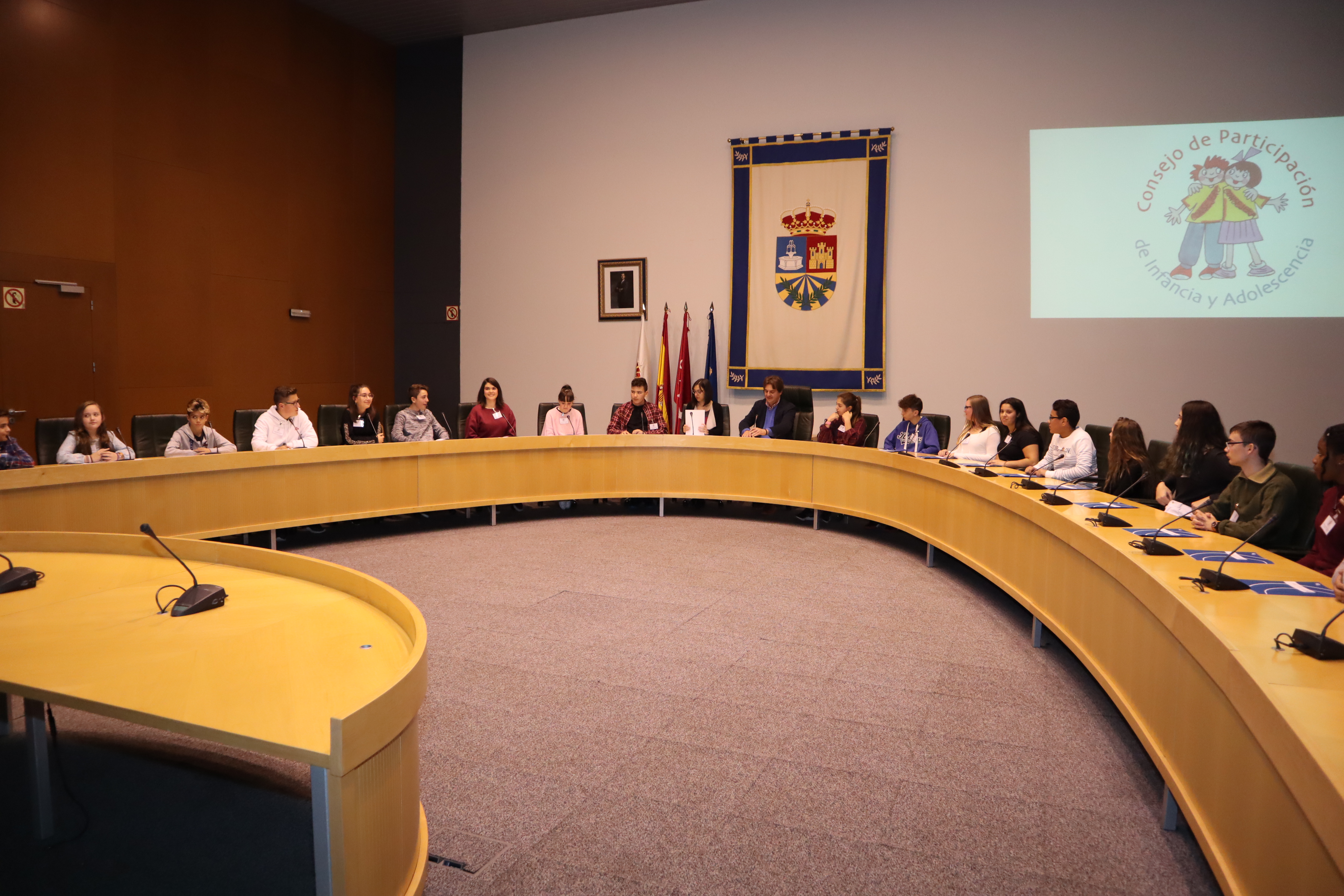 Niños y niñas sentados en torno a una gran mesa