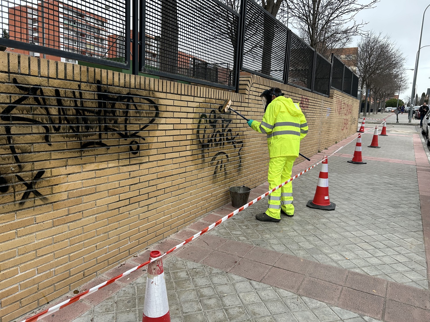 Operario limpiando un grafiti en un muro