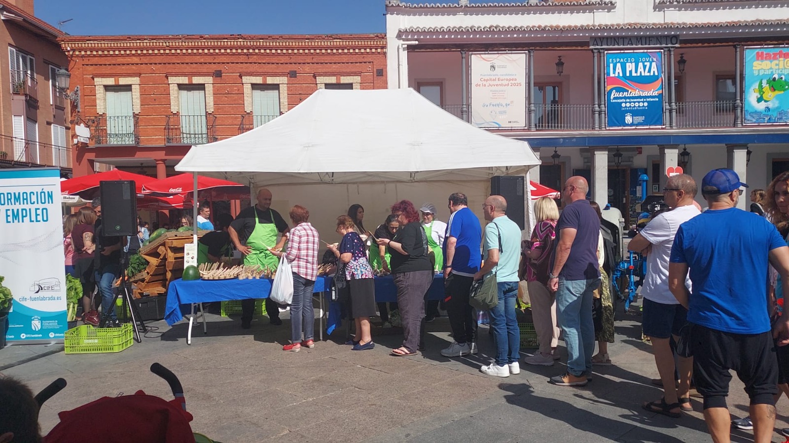 Puesto callejero de venta de hortalizas y personas haciendo cola para comprar 