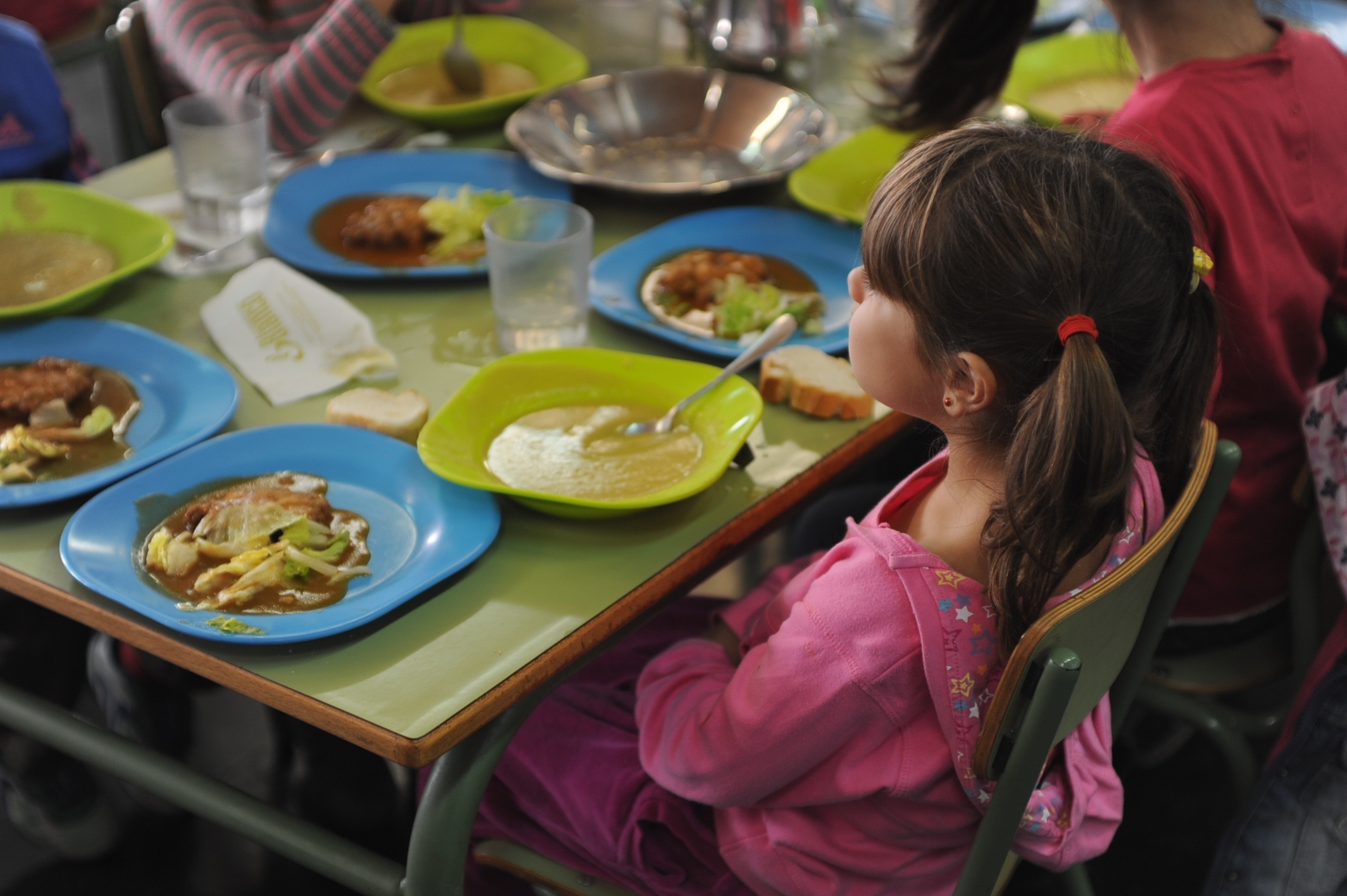 Niña comiendo en un comedor escolar