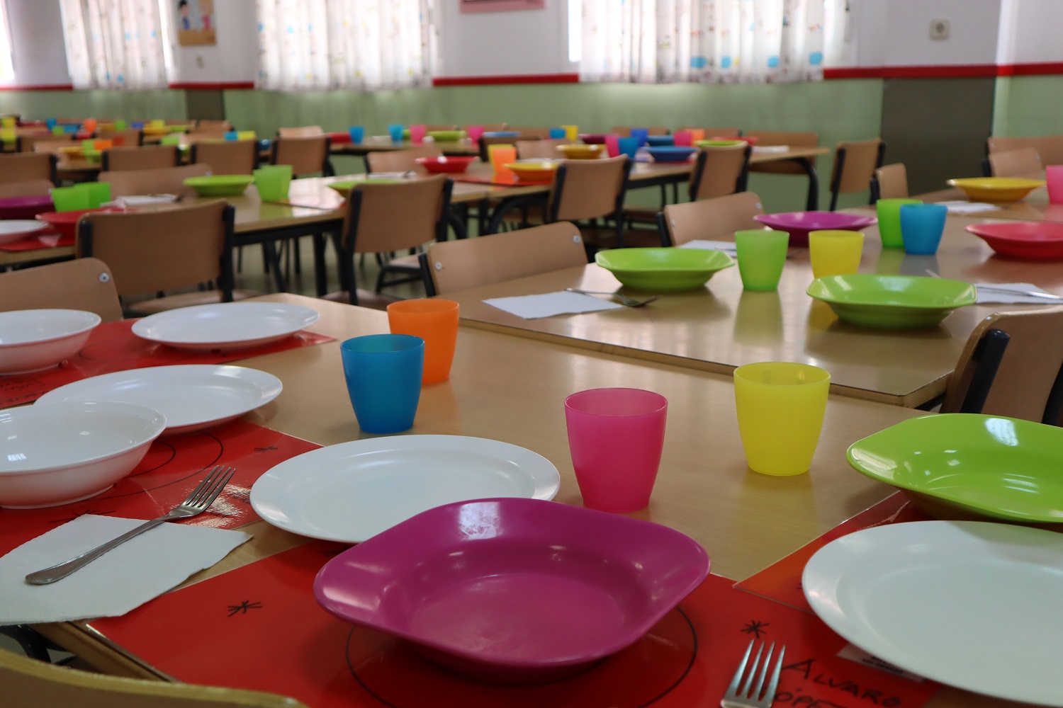 Imagen de un comedor escolar con las mesas preparadas 