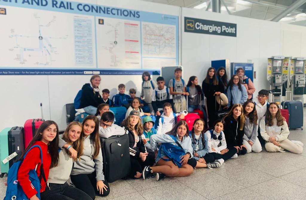Grupo de adolescentes con maletas y mochilas en una estación de transporte