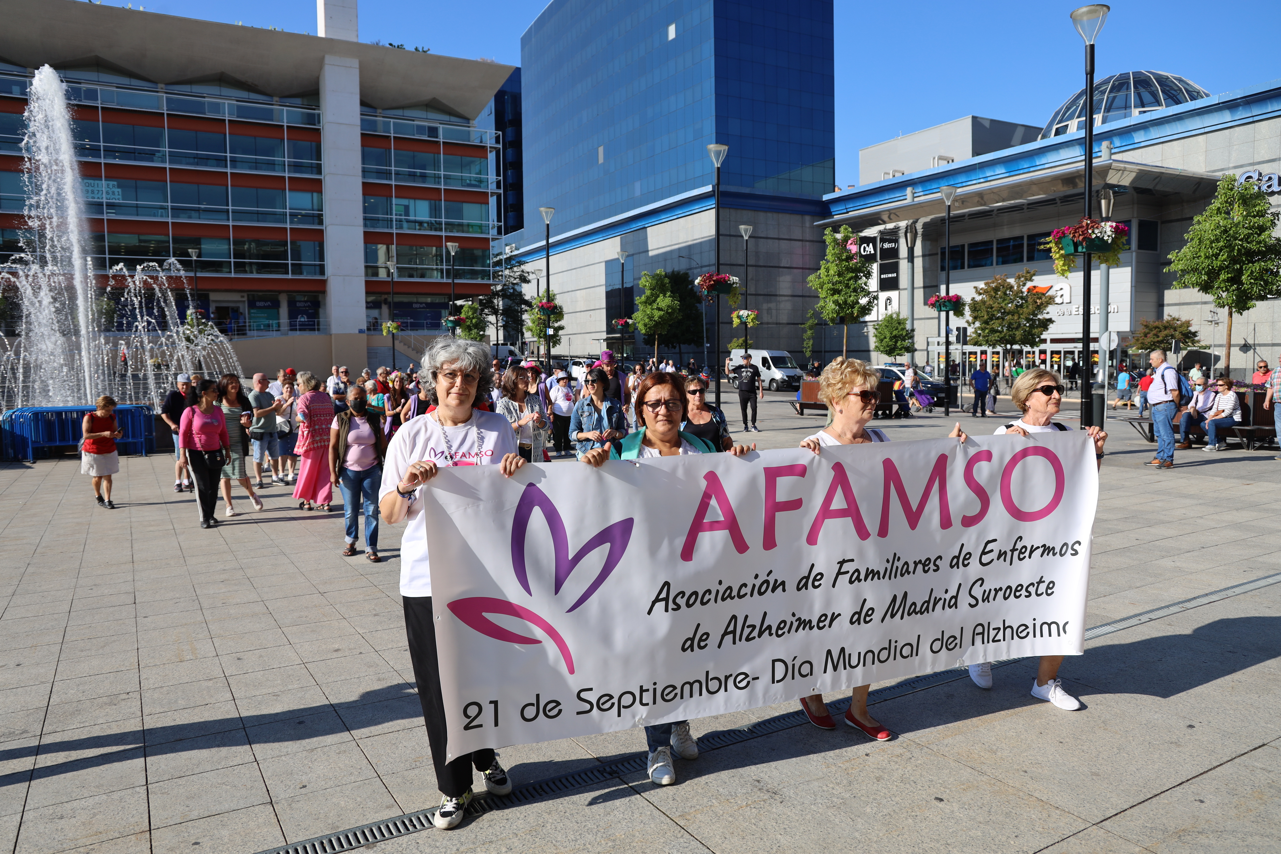 Un grupo de personas en la calle con una pancarta 