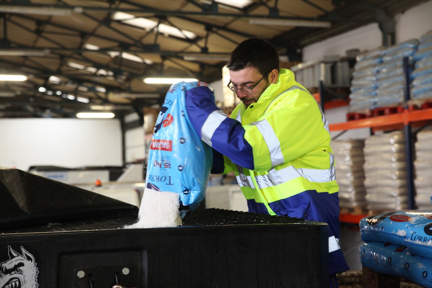 Operario vertiendo sal en un contenedor
