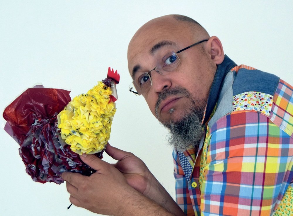 Un hombre con una gallina de papel