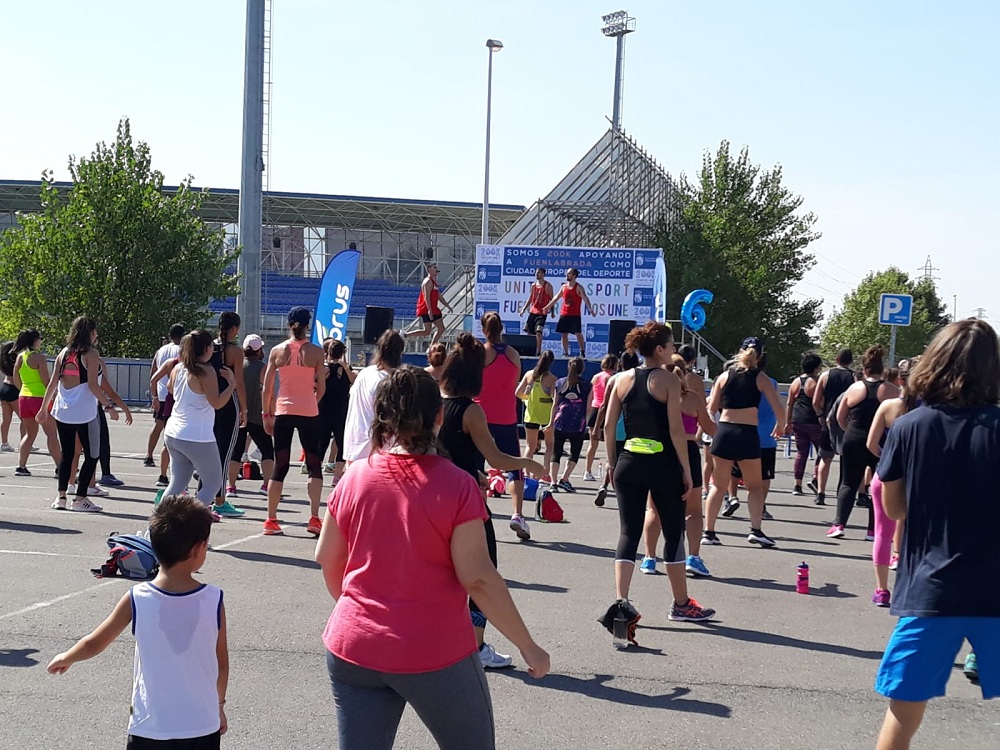 Personas siguiendo una clase deportiva en la calle