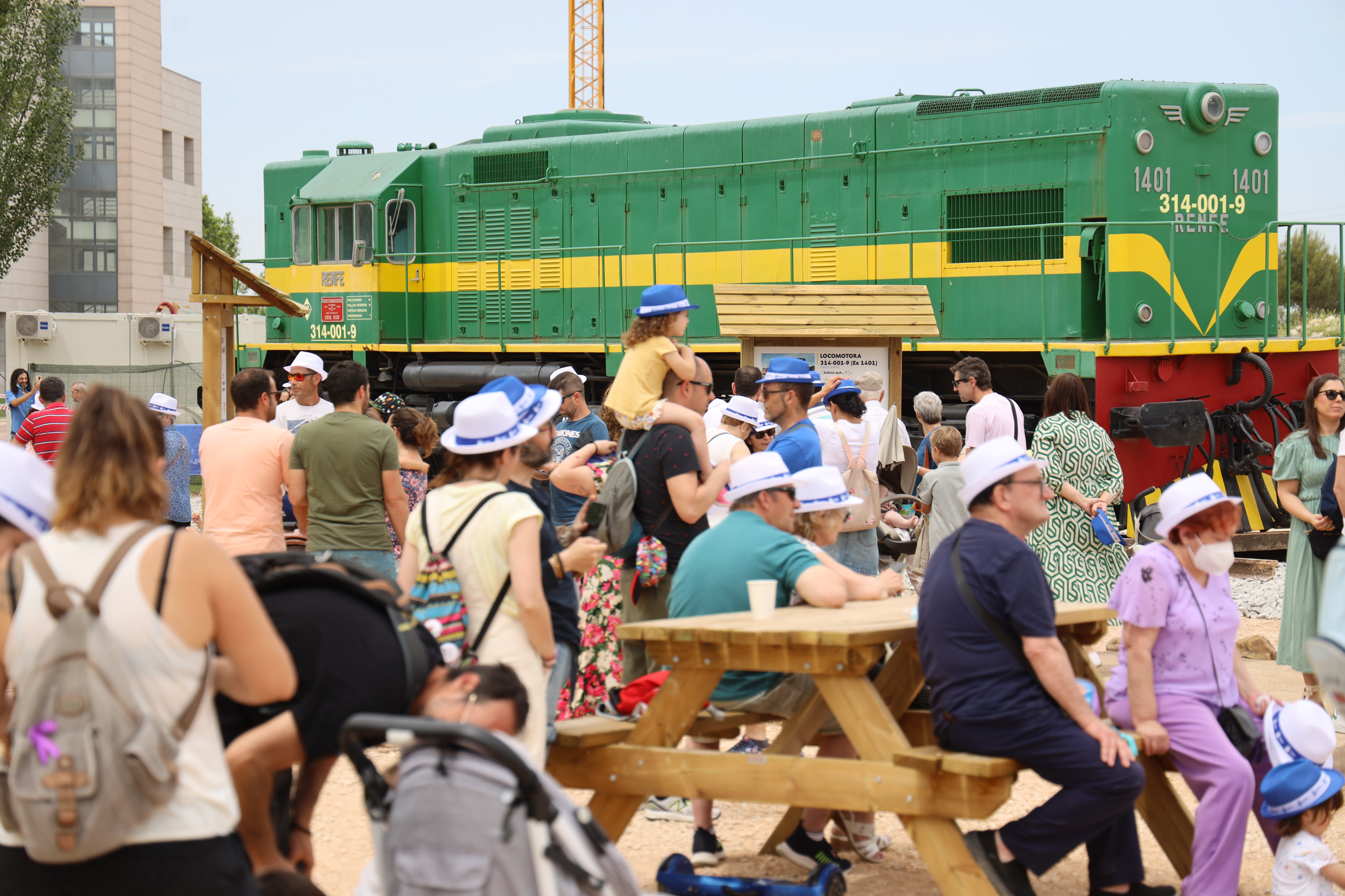 Un grupo de personas junto a una máquina histórica de tren 