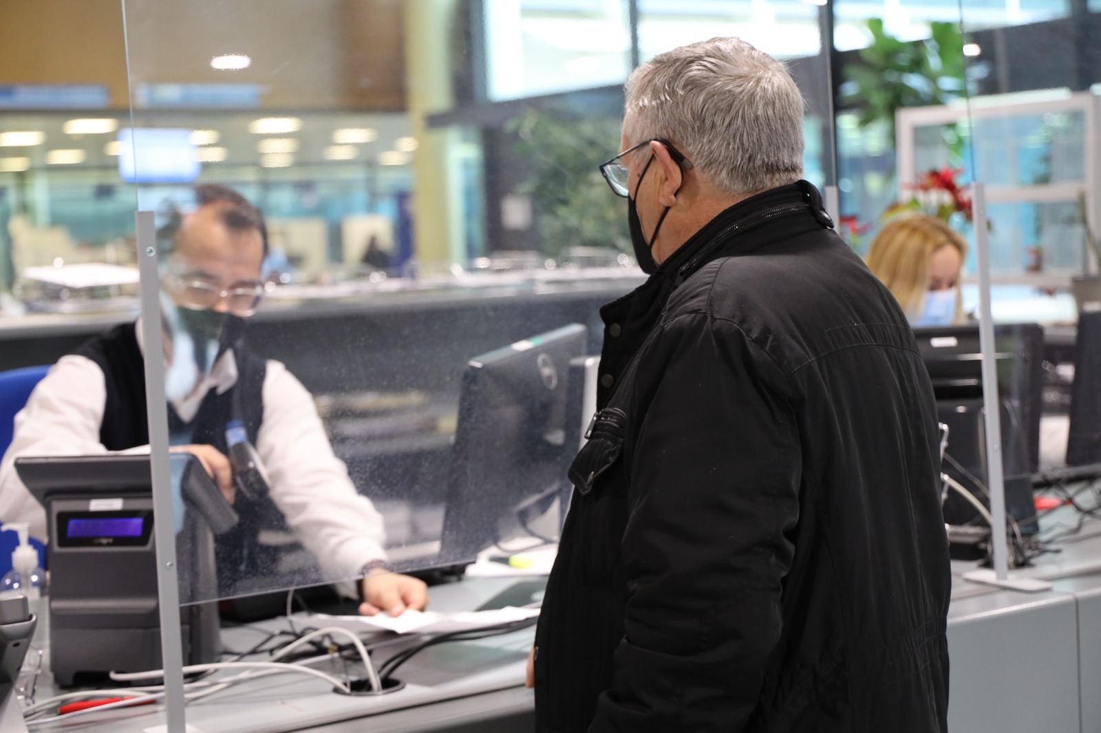 Un hombre  atiende en un mostrador a otro