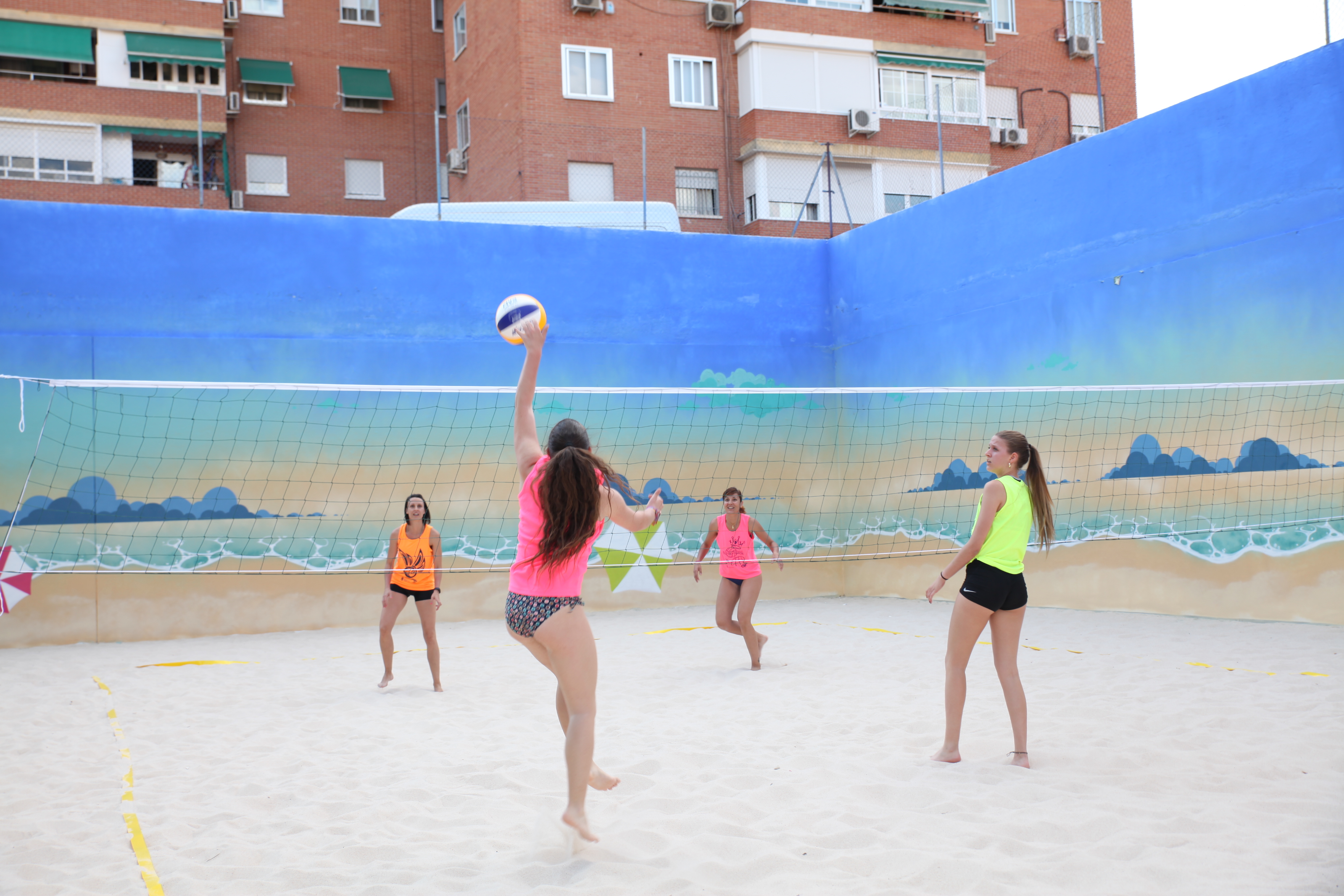 Chicas jugando al vóley playa en una pista urbana 