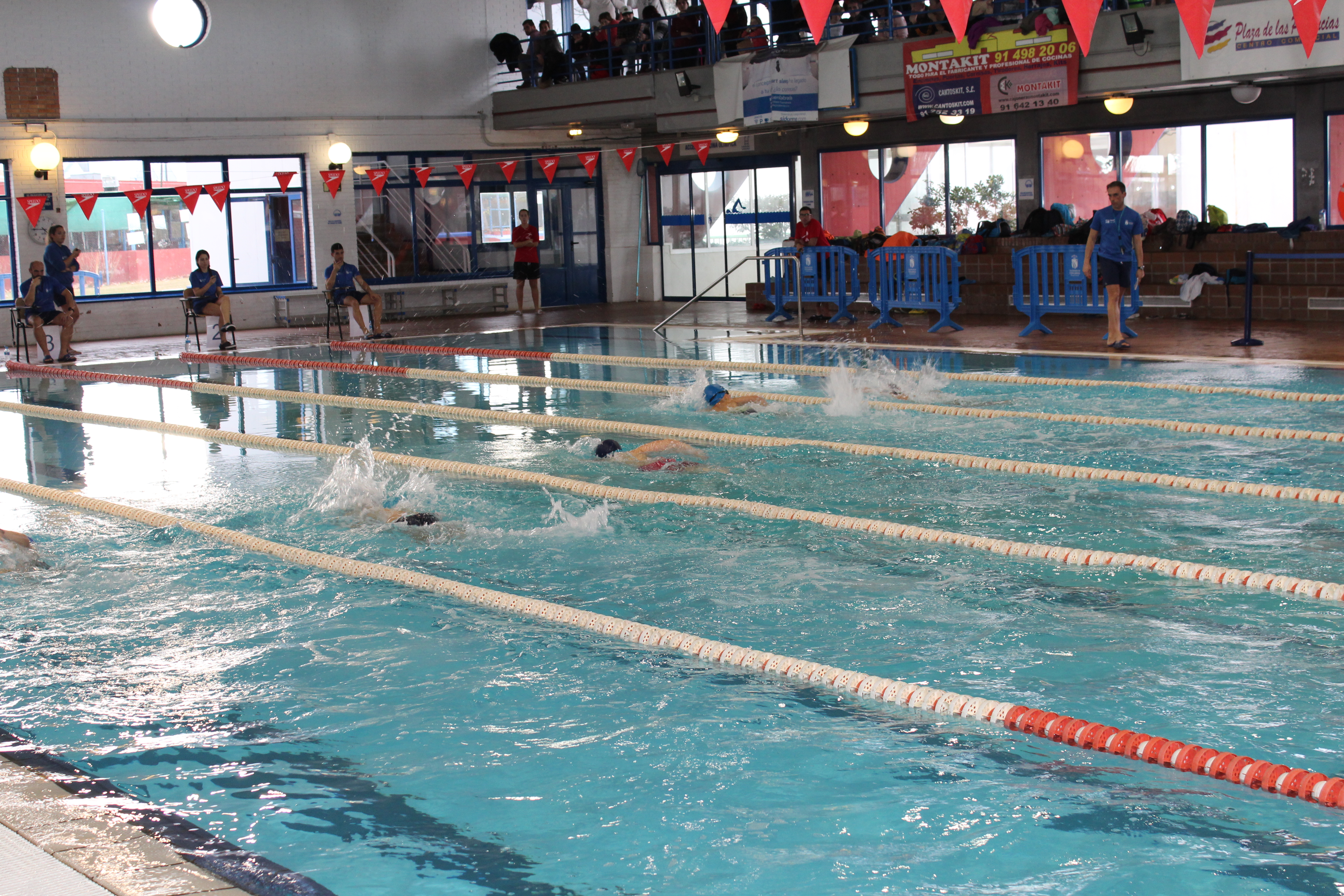 Un grupo de niños y niñas nadando en la piscina municipal