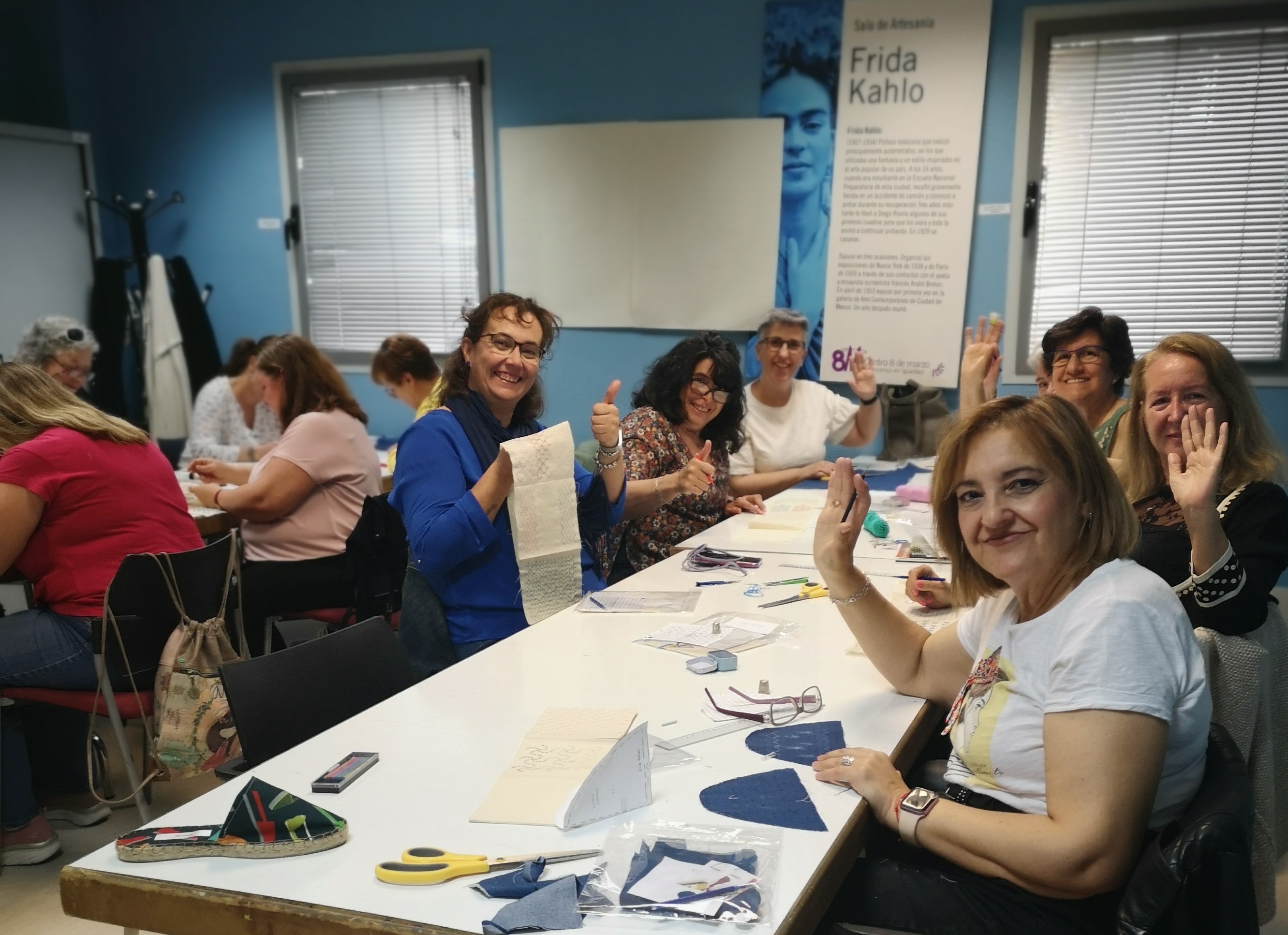 Un grupo de mujeres sentadas ante una mesa cosen