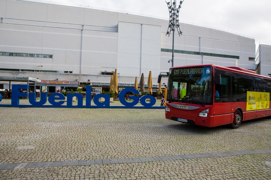 Autobús de la EMTF con el edifico del Tomas y Valiente detras y las letras Go, Fuenla, go