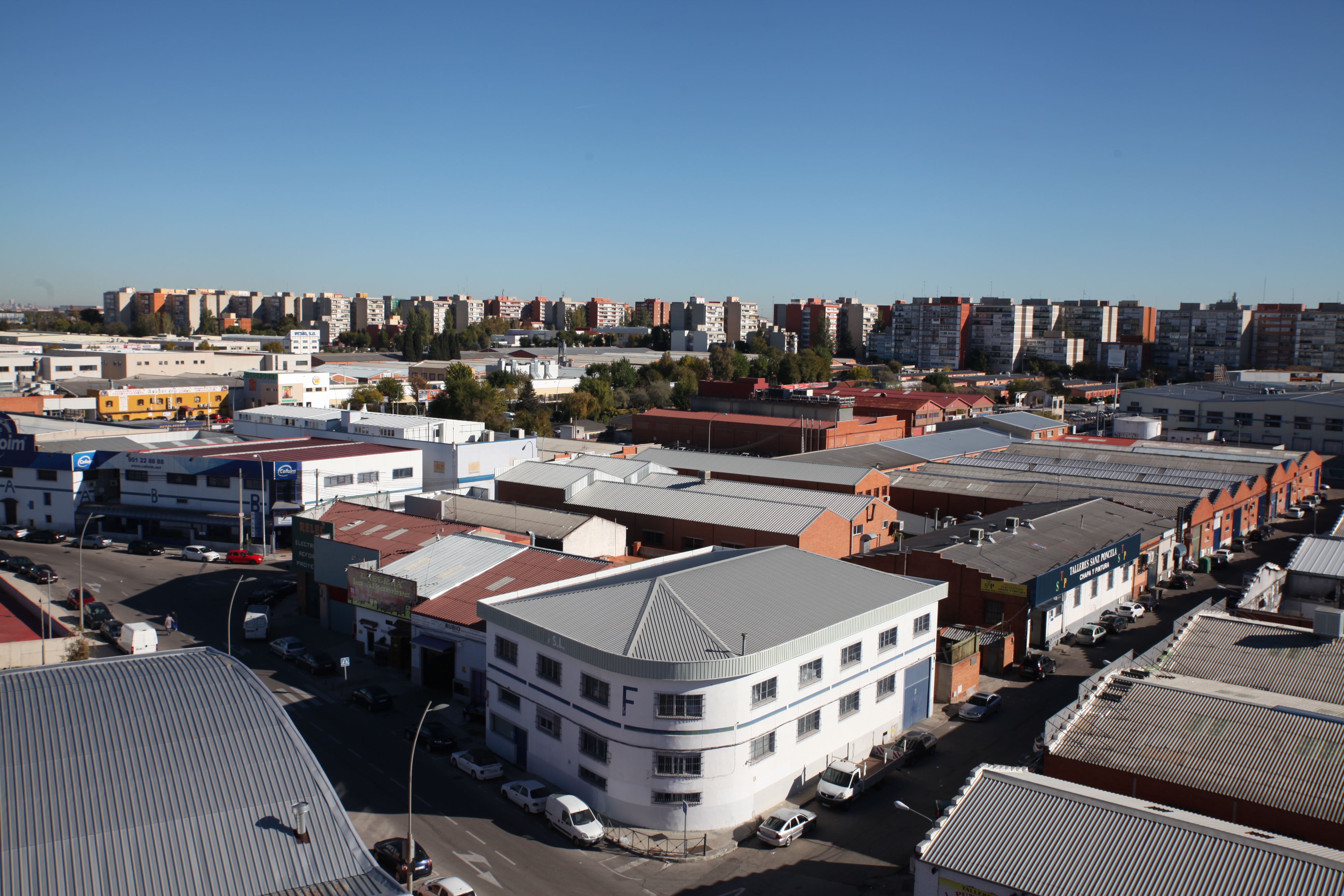 Naves industriales y al fondo bloques de viviendas  