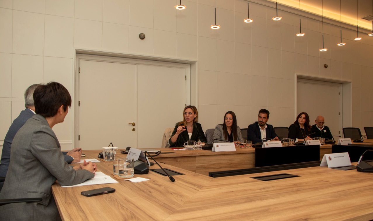 La ministra, alcaldes y alcaldesas reunido en un despacho