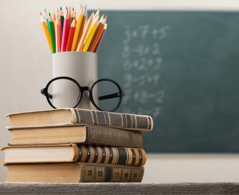 Lápices de colores y unas gafas sobre unos libros