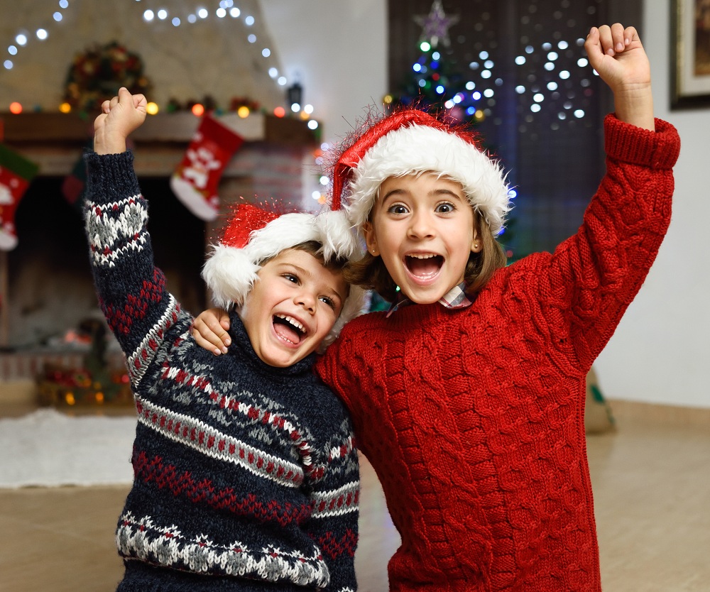 Un niño y una niña con gorros de Papá Noel