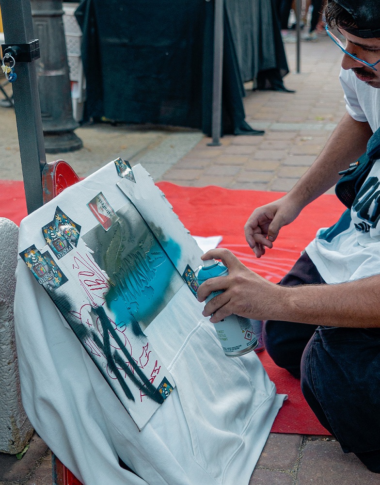 Artista pintando una sudadera con un spray