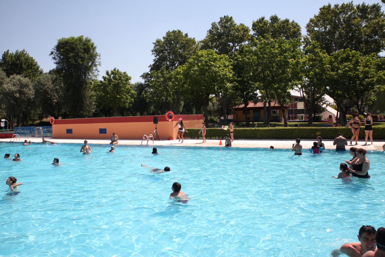Imagen de la piscina municipal con gente bañándose en verano
