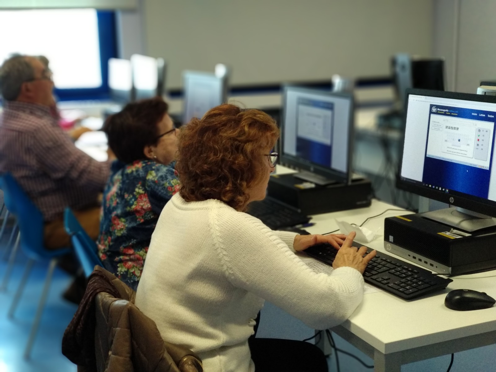 Personas mayores en un aula con ordenadores