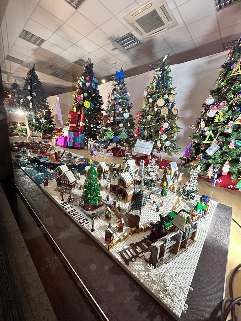 Pueblo construido con piezas de lego detrás árboles de Navidad