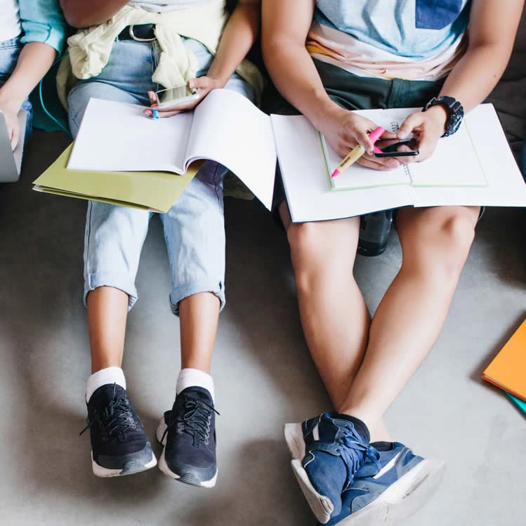 Niños sentados con cuadernos en sus rodillas
