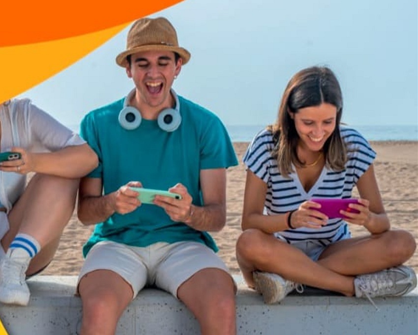 Jóvenes en la playa mirando el móvil