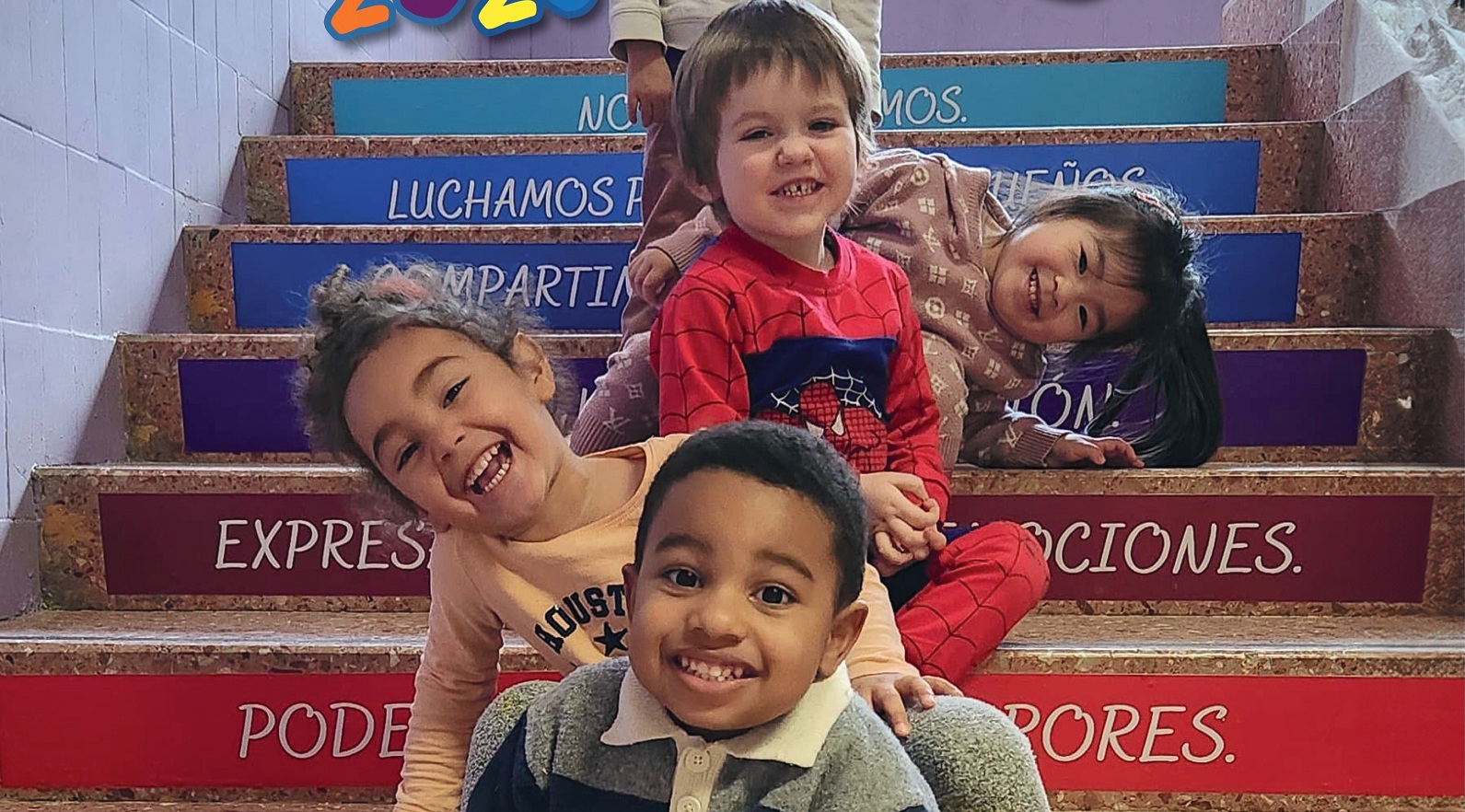 Niños de educación infantil sentados en una escalera