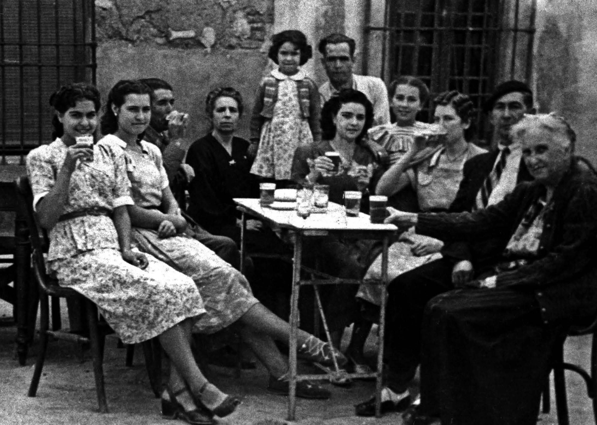 Mujeres y hombres sentados en la calle bebiendo cerveza