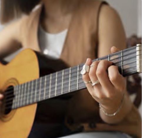 Detalle de una mujer tocando una guitarra española