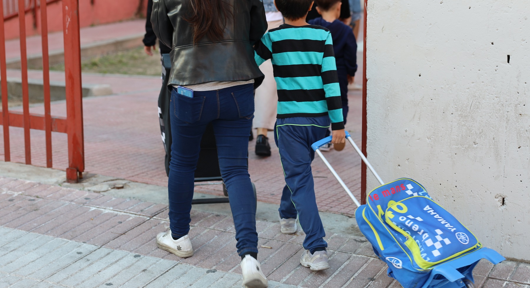 Foto de archivo Una mujer acompaña a su hijo al colegio