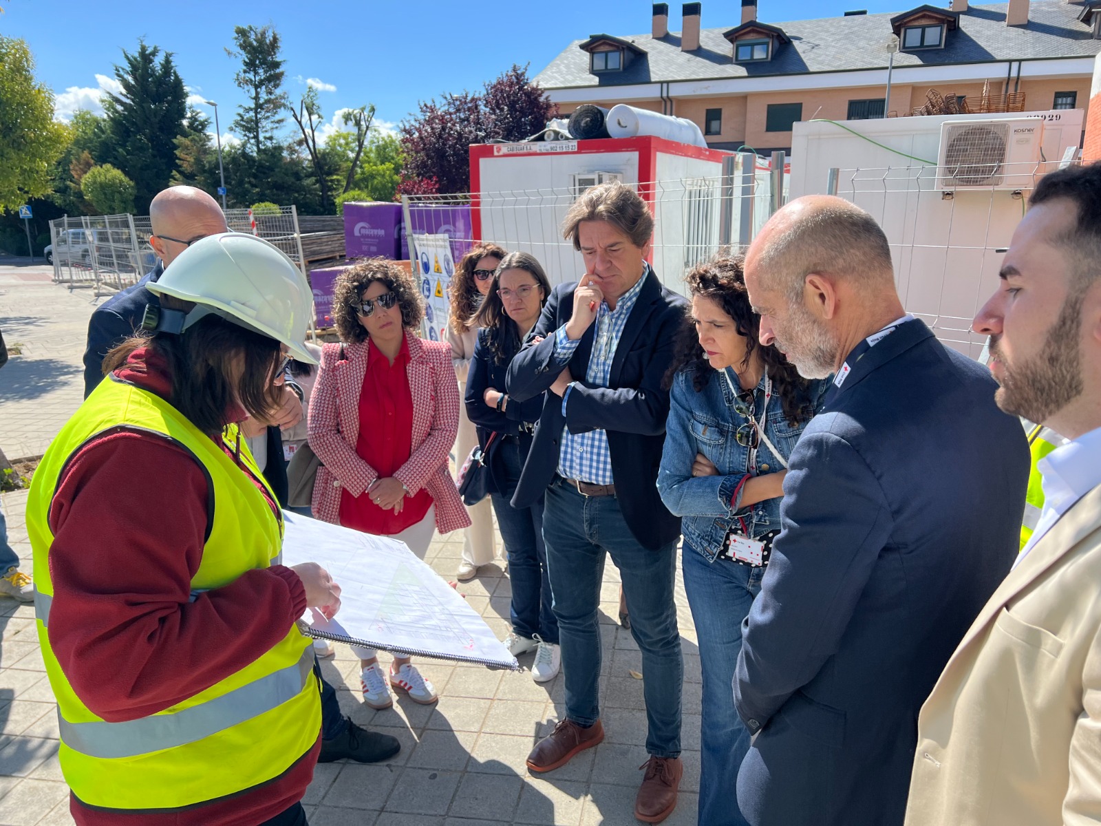 Una responsable de obra muestra un plano al alcalde y a otras cuatro personas